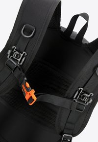 Mochila negra con tela de nylon texturizada, que cuenta con correas ajustables, clips de plástico y un panel trasero ventilado destacando acentos en naranja.