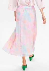 Gonna lunga plissettata in colori pastello (rosa, blu, giallo) con un design fluido. Presenta una vita elastica e un tessuto leggero e texturizzato.