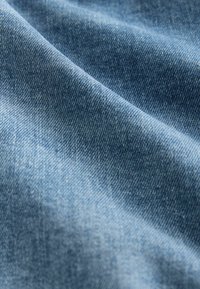 Traput od trapera svijetlo plave boje, prikazujući glatku teksturu s uzorkom tkanja. Materijal djeluje fleksibilno i izdržljivo.