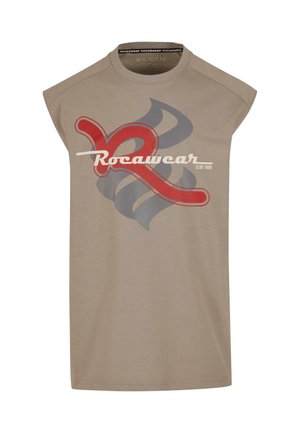 T-shirt sans manches beige présentant un grand logo graphique rouge et gris, avec "Rocawear CLUB 1999" imprimé en texte blanc.