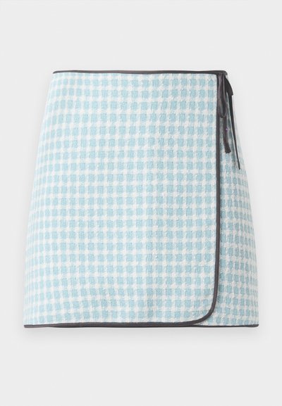 Wrap skirt in light blue and white checked pattern, featuring a soft texture and contrasting dark trim. Ties on the side for closure.