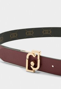 Cintura in pelle bordeaux con una fibbia in metallo dorato che presenta un design con logo. La superficie interna è verde scuro con un motivo di logo ripetuto.