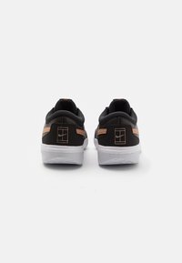 Sneaker nere con un design a profilo basso, caratterizzate da una parte superiore testurizzata, dettagli arancioni e una suola in gomma bianca. Logo visibile sul tallone.