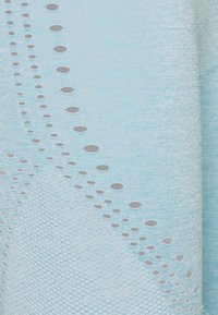 Tessuto lavorato a maglia azzurro chiaro con un motivo texturizzato caratterizzato da piccole forme ovali ritagliate lungo una linea diagonale. Texture morbida e liscia.