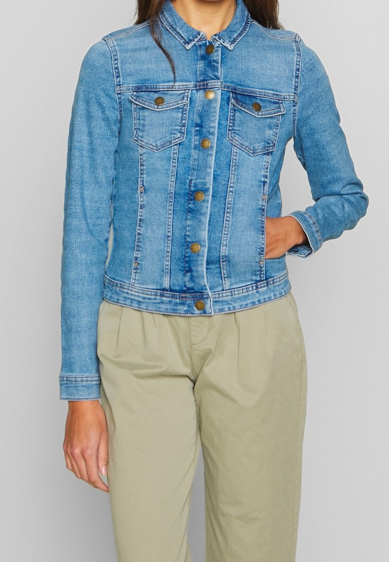 Light blue denim jacket with a classic collar, button closure, and two chest pockets. Features long sleeves and a tailored fit.