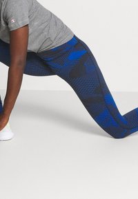 Blå och svarta leggings med mönster och en elegant design. Tight passform, tillverkade av stretchigt material, med strukturerade detaljer och en slät yta.