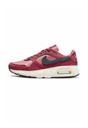 Baskets Nike dans des teintes de rose et de bordeaux. Comprend des matières en daim et en mesh, un swoosh accent vert, et une semelle intermédiaire blanche avec un unité AIR.