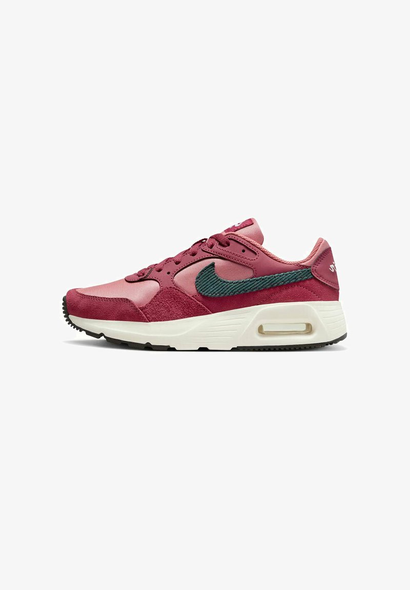 Baskets Nike dans des teintes de rose et de bordeaux. Comprend des matières en daim et en mesh, un swoosh accent vert, et une semelle intermédiaire blanche avec un unité AIR.
