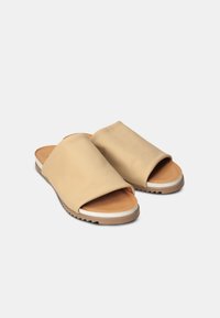 Beige slide sandals made of smooth leather with a wide strap; tan footbed and textured rubber sole with white accent.