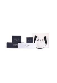 Quattro scatole regalo in bianco e nero, con il marchio "MYC PARIS"; una borsa da shopping nera con manico in seta.