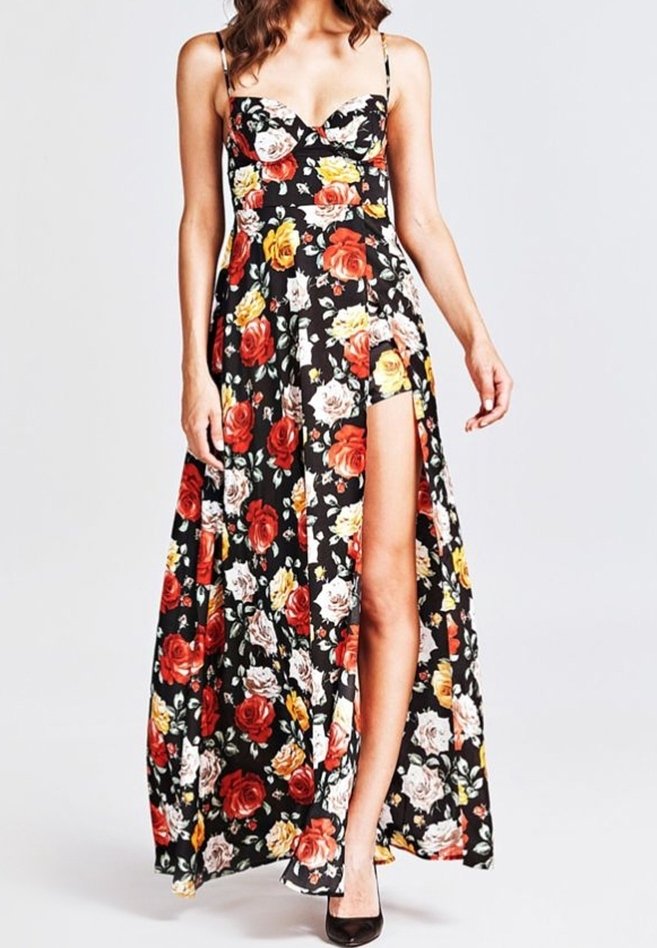 Robe maxi fleurie avec fond noir, mettant en vedette des roses rouges, jaunes et blanches vibrantes. Design sans bretelles avec une fente haute sur la cuisse. Texture de tissu lisse.