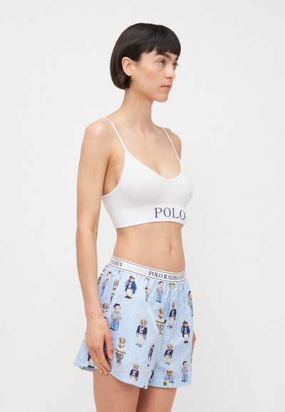 White bralette with “POLO” logo and blue striped shorts featuring cartoon dog patterns. Cotton material and elastic waistband.