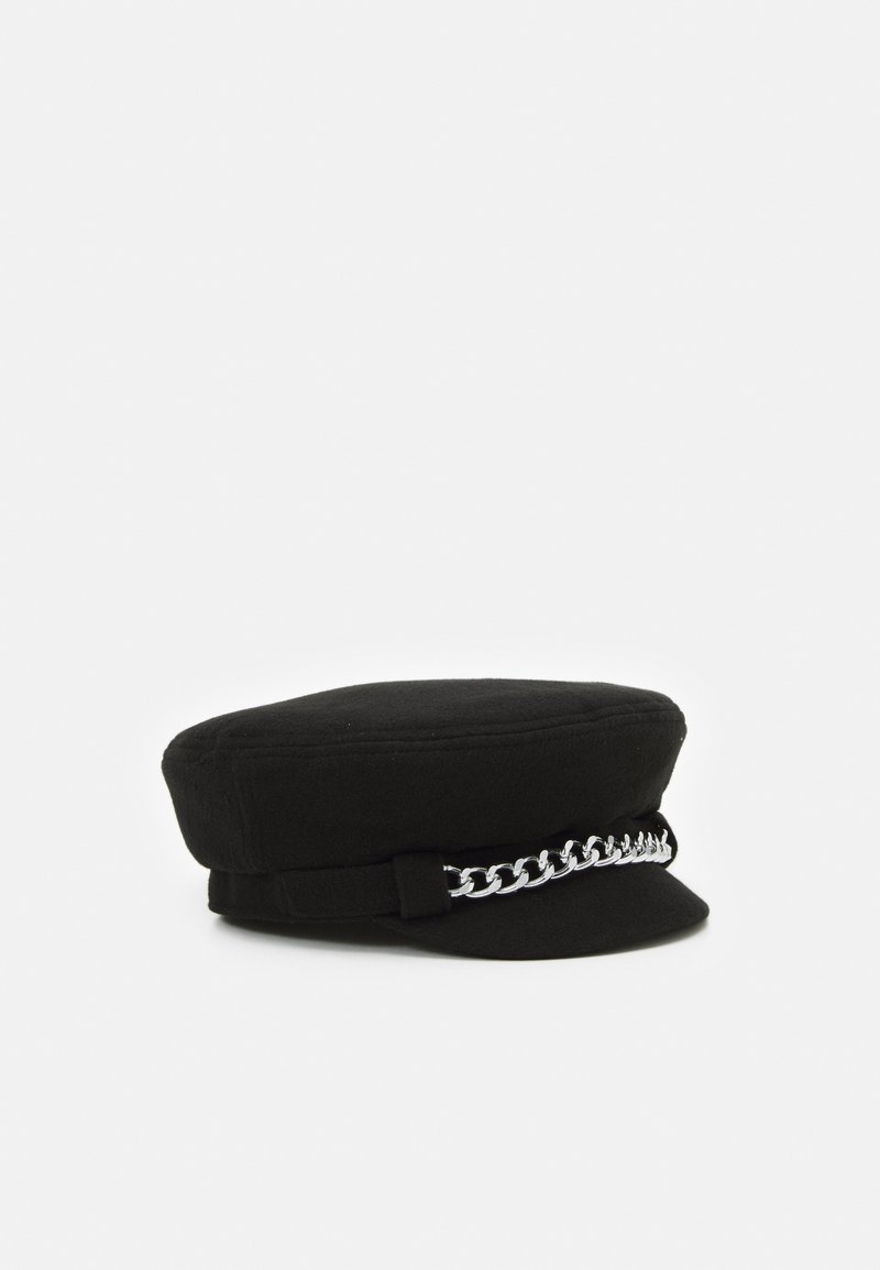 Chapeau noir à plateau plat avec bord court et détail de chaîne argentée sur le devant, présenté sur un fond blanc.