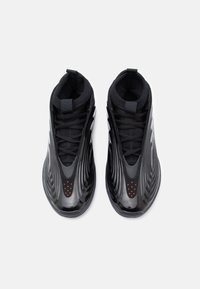 Μαύρα αθλητικά παπούτσια με γυαλιστερή, κυματιστή σχεδίαση. Κατασκευασμένα από πλέγμα και συνθετικά υλικά, με κόκκινες διάτρητες λεπτομέρειες στο δάχτυλο και μαύρες κορδέλες.