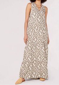Robe maxi beige clair avec un motif géométrique marron. Caractéristiques : col en V, sans manches et jupe à volants. Tissu texturé.