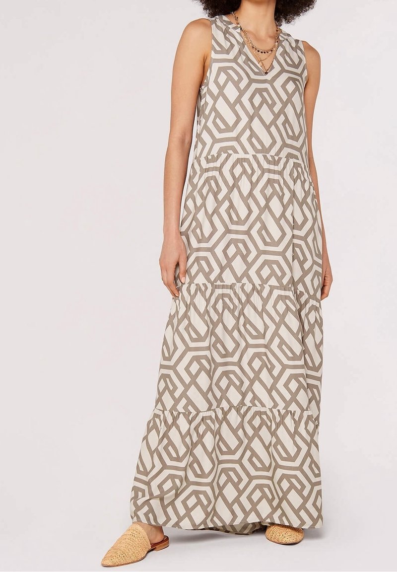 Robe maxi beige clair avec un motif géométrique marron. Caractéristiques : col en V, sans manches et jupe à volants. Tissu texturé.