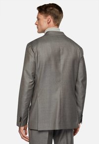 Gray tailored suit jacket with a notch lapel, single vent, and buttoned cuffs. Smooth fabric with a subtle texture and structured silhouette.
