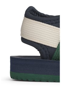 Πλατφόρμα σανδάλι με μπλε υφασμάτινο πάνω μέρος, μπεζ πλεγμένο λουράκι και πράσινη στρωματοποιημένη λαστιχένια σόλα με υφή.