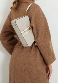 Borsa a mano rettangolare beige con dettagli in oro, caratterizzata da una superficie texture, due strisce bianche e una singola tracolla regolabile.