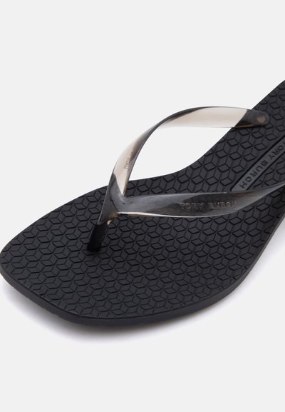 Sandale tong noire texturée avec des brides translucides et le marquage "Tory Burch" sur la semelle intérieure et la bride.