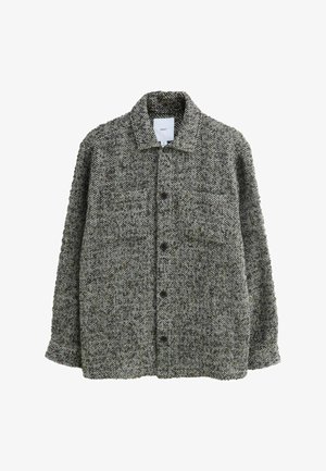 Jasje met visgraatpatroon in grijs en zwart, gemaakt van gestructureerde stof. Bevat een kraag en twee voorkruiszakken met knopen.