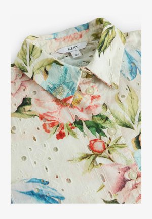 Blumenhemd mit weißem Grund, das farbenfrohe Blumenmuster präsentiert. Dekorative Spitzen-Details an den Ärmeln, Knopfverschluss und ein spitzer Kragen.