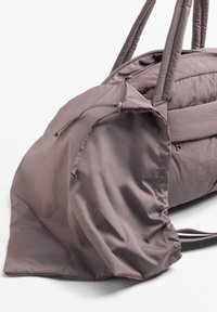 Siva torba iz najlona s zaobljeno obliko, dvojni naramni trakovi in zapiranje z zatezno vrvico. Gladek videz z minimalnimi detajli.