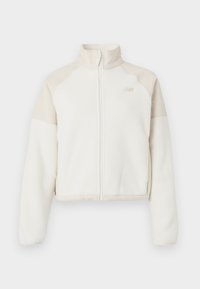 Strihaná fleecová bunda v off-white farbe s svetlo béžovými akcentmi, plný zips, vysoký golier a vyšívané logo na hrudi. Mäkká textúra.