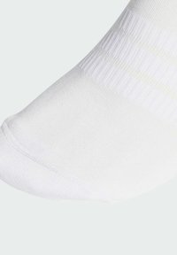 Biela členková ponožka z hladkej tkaniny, s vrúbkovanou textúrou na vrchu a bezšvovou špičkou pre pohodlie a dobré priliehanie.