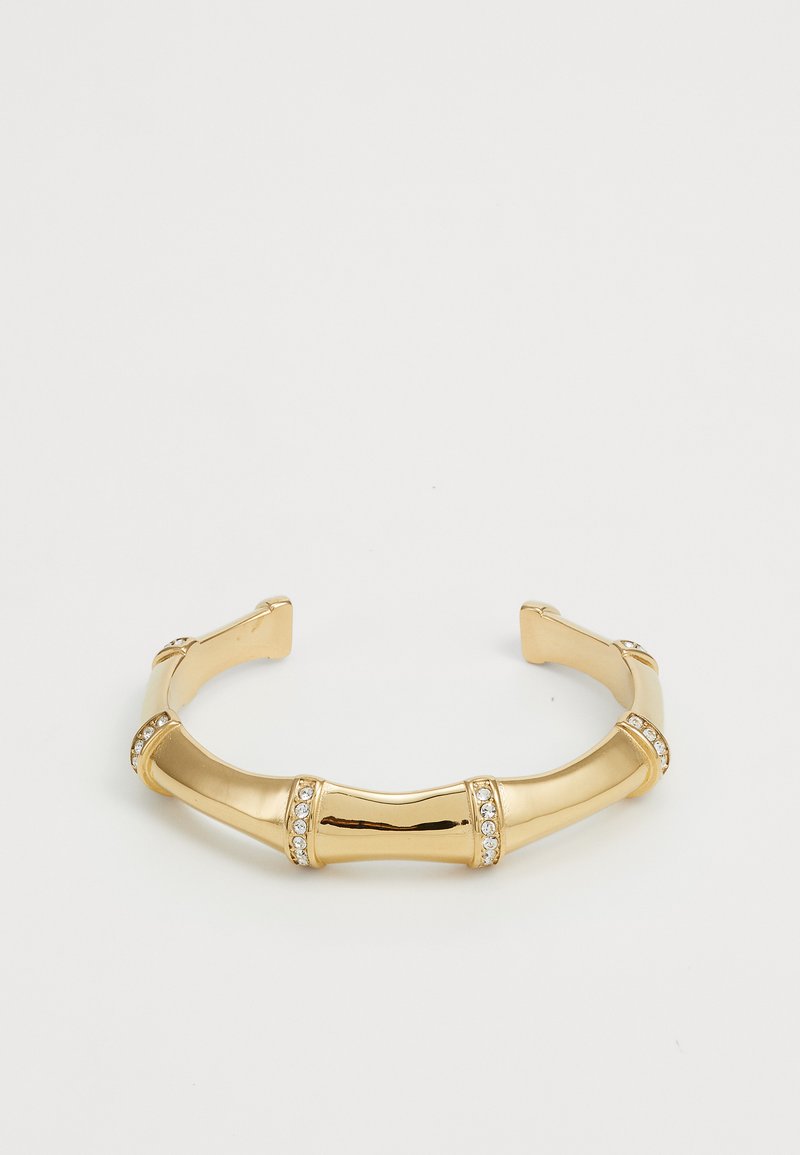 Bracciale cuff in oro con design a bambù, caratterizzato da sezioni lisce e lucide, decorato con piccole pietre preziose trasparenti lungo i bordi.