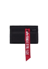 Cartera de tela negra con dos compartimentos con cremallera. Cuenta con una correa roja con el texto "REMOVE BEFORE FLIGHT". Diseño rectangular sencillo.