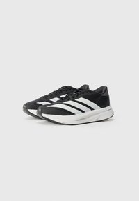 Chaussures de sport noires avec des rayures blanches, tige en maille et col rembourré. Présente une semelle texturée pour l'adhérence et la durabilité.