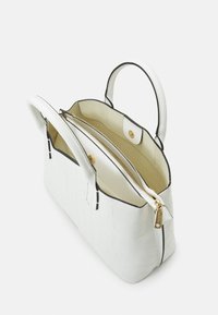 White faux leather handbag with a textured crocodile pattern, black trim, dual handles, and a zippered main compartment with golden hardware.