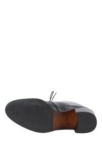Pantof de piele neagră cu un exterior neted, vârful rotunjit și o talpă plată din cauciuc. Include șireturi decorative și este marcat cu mărimea 38.
