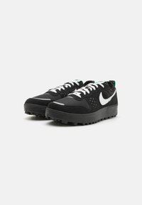 Tênis de desporto pretos com parte superior em malha e camurça, bota Nike branca, atacadores brancos, sola de borracha com padrão de tração, gola acolchoada.