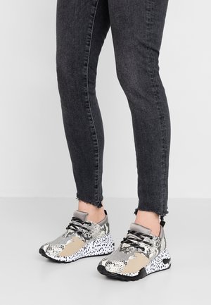 Sneakers met een mix van textuur van slangenprint en beige panelen, voorzien van zwarte veters, een gevoerde zool en een grijze kraag.