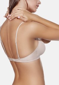 Sujetador con aros color beige, con tirantes finos ajustables y un acabado de tela suave y liso, que cuenta con un cierre de gancho y ojal en la parte posterior.