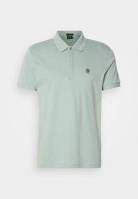 Polo de manga corta verde claro con cuello, tapeta de dos botones y pequeño logotipo bordado de la "B" en el lado izquierdo del pecho.