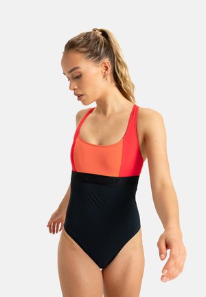 Maillot de bain une pièce avec un design coloré, comprenant un haut corail vif et un bas noir uni, fabriqué en tissu extensible et agrémenté d'une bande de logo noire.