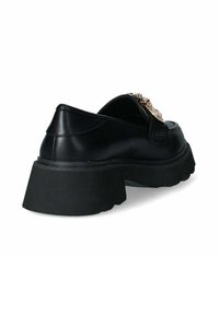 Scarpa in pelle nera con suola piatta nera spessa, dotata di un accentuazione decorativa di catena dorata su un lato. Texture liscia e design minimal.