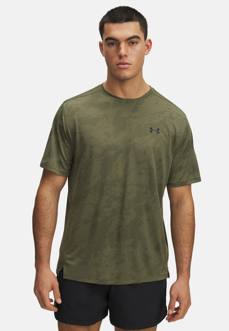 Športna majica kratkih rokavov v olivno zeleni barvi z nežnim vzorcem maskirnega tiska, okroglim izrezom in črnim logotipom na prsih.