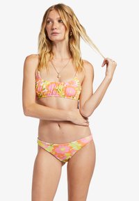 Kvetinový bikiny set v ružovej, zelenej a oranžovej farbe s volánovým vrchom a nízkym spodným dielom. Vyrobené z elastickej tkaniny s hladkým povrchom.