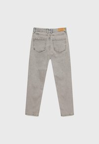 Harmaan farkun suorat lahkeet, joissa on keskikorkea vyötärö, viisi taskua ja nahkamerkki vyötärönauhassa.