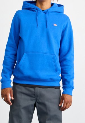 Blauwe katoenen hoodie met een kangoeroezak, geribbelde manchetten en een subtiel logopatch op de borst. Zachte textuur en medium dikte.