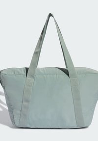 Lysegrøn mulepose lavet af blødt stof med to robuste håndtag, lynlås lukning øverst og en struktureret rektangulær form.