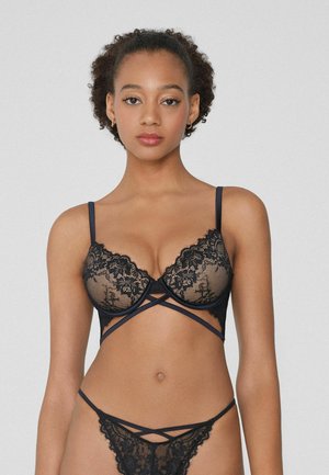 Black lace lingerie set featuring a push-up bra with crisscross straps and a matching thong. Detailed lace pattern, smooth finish.