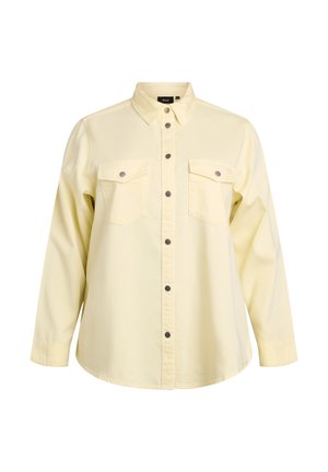 Camicia giallo chiaro a maniche lunghe con bottoni a pressione in metallo, due tasche sul petto e colletto standard.