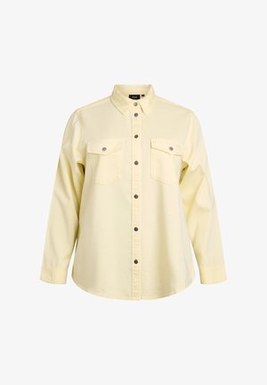 Camicia giallo chiaro a maniche lunghe con bottoni a pressione in metallo, due tasche sul petto e colletto standard.