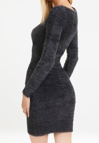 Sovit tummaharmaa mekko, joka on valmistettu pörröisestä kankaasta. Siinä on pitkät hihat ja ribattu helma, pyöreä kaula-aukko sekä sileä pinta.