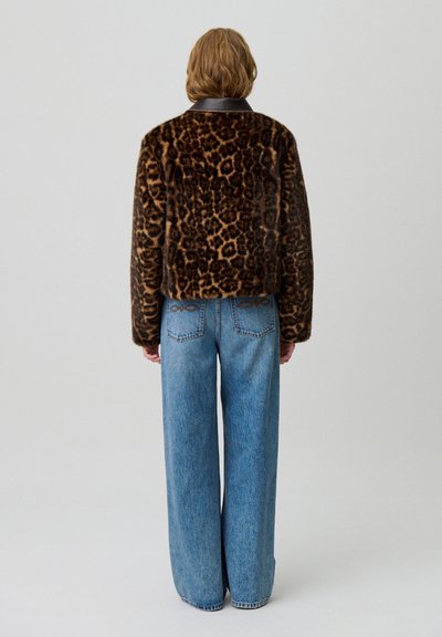 Giacca in pelliccia sintetica stampa leopardo con colletto in pelle, abbinata a jeans in denim blu a vita alta, dal taglio a gamba larga, con cuciture di accentuazione sul retro.